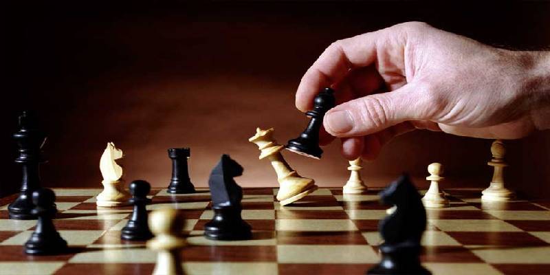 White queen killed by a black bishop on a chess board during a chess game.